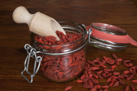 Goji berries in a jar on wooden tableの写真素材
