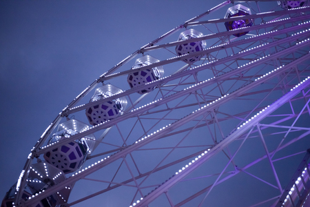 Violet ferris wheel illuminated at nightの写真素材