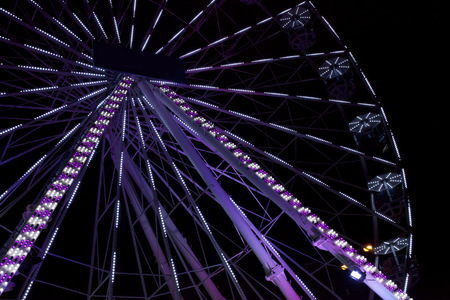 Violet ferris wheel illuminated at nightの写真素材