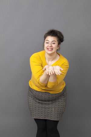 cheerful 20s big woman acting thrilled, wearing colorful sweater and skirt, expressing joy and excitement with hand gestureの写真素材