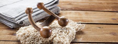 concept of massage and washing-up with loofah glove, wooden accessory and towel for wellnessの写真素材