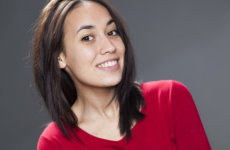 closeup on smiling multiethnic 20s girl wearing red sweater expressing happiness and wellbeingの写真素材