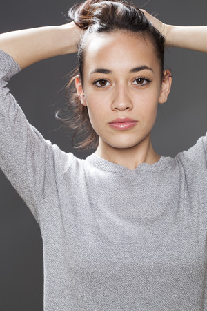 natural smile - radiant young multi-ethnic girl playing with her hair for seduction and wellbeing,studio shotの写真素材
