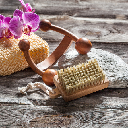 spa beauty treatment concept - symbols of massage, washing-up and nail care for indulging yourself set on old wood, gray texture stone and pink orchid flower background for genuine body care decorの写真素材