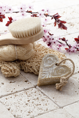 wellbeing still-life - back brush, loofah and heart-shape soap with cherry blossom flowers for soft exfoliation and hygiene at ayurveda spaの写真素材
