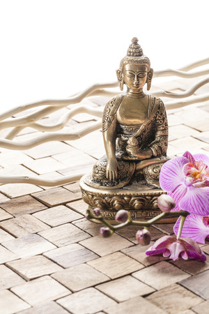 spirituality still-life - meditating before ayurveda massage, Buddha on wood background with pink orchid flowersの写真素材