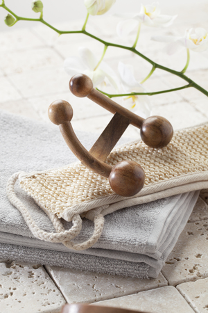 wellbeing still-life - exfoliating and pampering massage set on towels on limestone with beautiful white orchid flowers for purityの写真素材