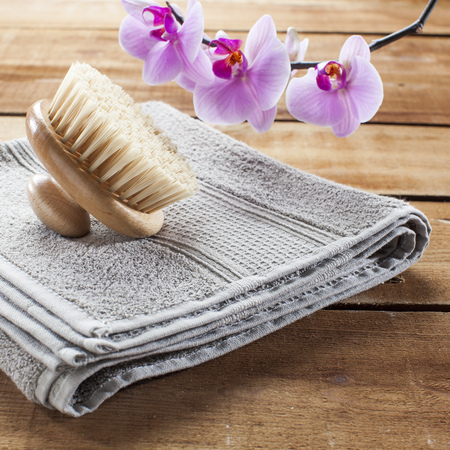 back brush for beauty ritual at spa center with towel and flowers for femininityの写真素材