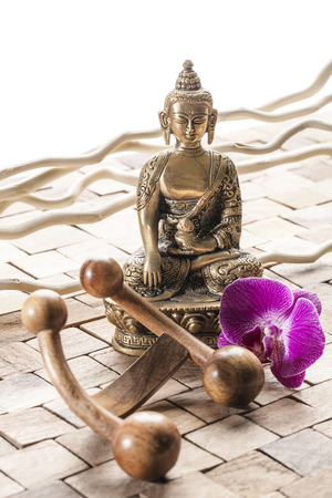 meditation still-life - meditating before ayurveda massage, Buddha on wood background with pink orchid flowersの写真素材