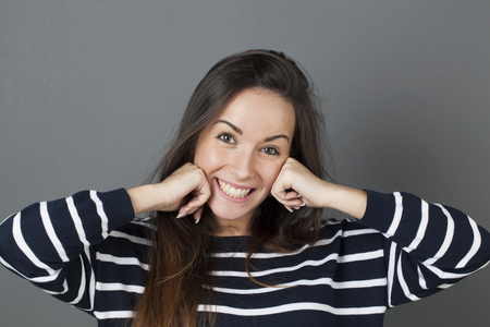 surprise and success concept - thrilled 20s woman putting both hands on her face smiling for surprise and happinessの写真素材