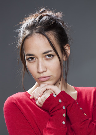 seduction concept - portrait of seductive mixed-race girl staring protecting herself with hands to her chest for comfort and self-assurance,studio shotの写真素材