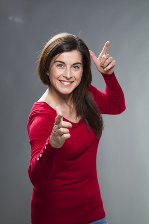 success concept - dynamic young woman pointing or aiming at something for winning concept,using body languageの写真素材