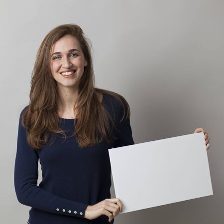 thrilled young girl holding a white communication board with positive news onの写真素材
