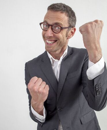 expressive corporate man concept - joyful middle age businessman expressing energy and success with hand gesture,wide angle on white backgroundの写真素材