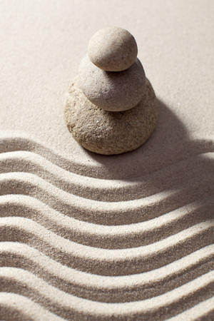 top view of pebbles in balance before waves in sand for progression or spirituality conceptの写真素材