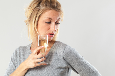 female drinker - disgusted young blond woman drinking a wine glass suffering from booze nausea and...