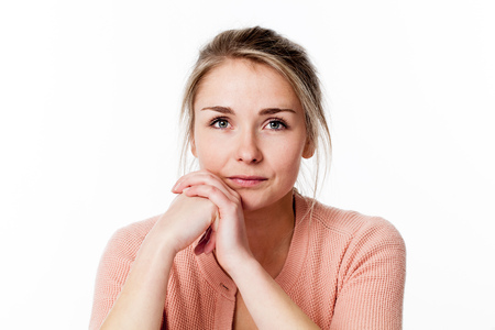 reflection concept - closeup of thoughtful beautiful young blond woman with both hands together for...