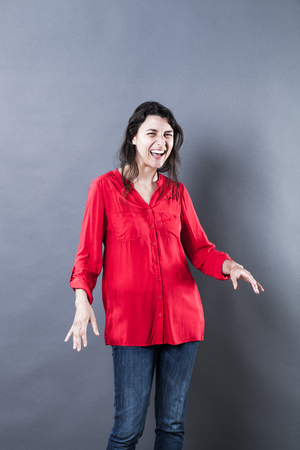 female natural laughter portrait - joyful young woman with natural fine hair standing, bursting out laughing, blue texture effects, studio shotの写真素材