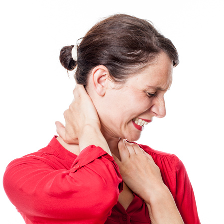 young woman in pain, suffering from stress, touching the back of her neck with her hands to relax cramps, white background studio shotの写真素材