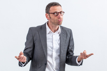 blaming concept - mad middle aged entrepreneur with eyeglasses accusing or denouncing someone with his index pointed, white backgroundの写真素材