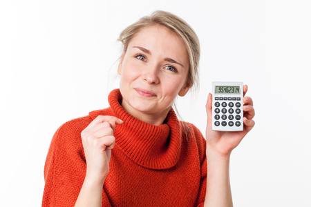 successful savings - happy young blond woman smiling, showing her calculator with positive cost solutions, isolated over white backgroundの写真素材