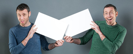 concept of confusion in message with young casual man displaying a copy space communication with positive and negative expressions, indoorsの写真素材