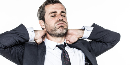 tired young bearded businessman with cheeks puffed, relaxing his tensed neck against corporate exhaustion, isolated over white backgroundの写真素材