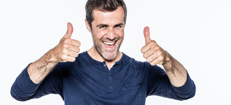 satisfied young bearded man with thumbs up showing his success and optimism with joy and energy, isolated, white backgroundの写真素材