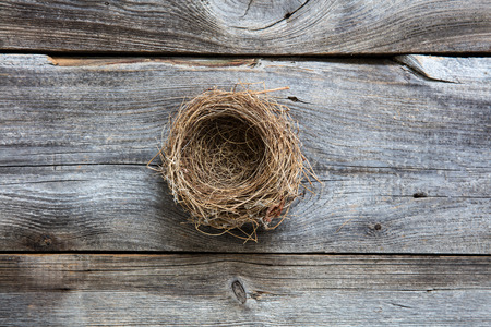 empty bird nest on old vintage dark wood for metaphor of genuine comfortable home or sustainable investment in country life, flat layの写真素材