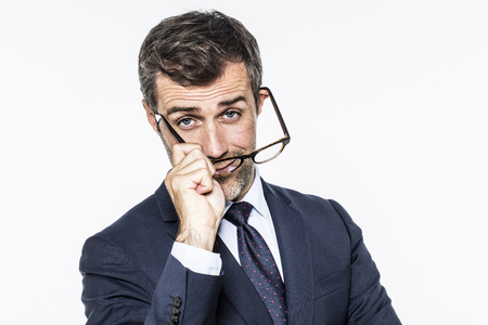 smiling middle aged businessman with a tie putting his eyeglasses for corporate vision, copy space, white background studioの写真素材