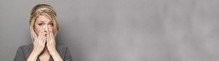 sadness concept - portrait of trendy young blond woman with grey sweater expressing disappointment...