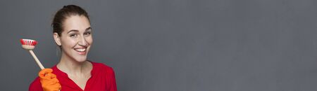 fun cleaning concept - attractive 20s girl holding a dish brush with pride for efficient and satisfying housekeeping,studio shot, gray copy space panoramaの写真素材