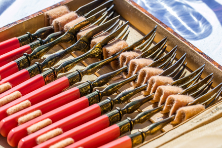 display of old oxidized silverware with beautiful red silver forks in their antique box for collectors and household nostalgia sold at outdoor garage saleの写真素材