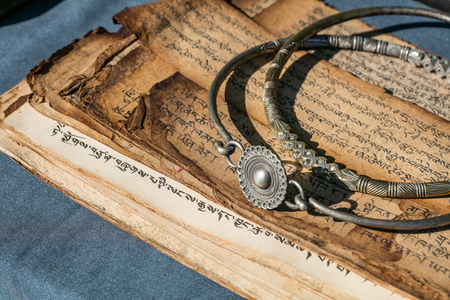 antique Tibetan bronze jewels and ancient praying books, Chinese sale specialist at market, outdoorsの写真素材