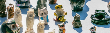 collection of figurines of small owls and birds for porcelain or ceramic collection or decoration displayed at street fairの写真素材