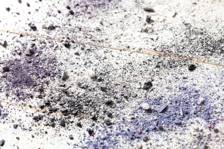 Cosmetics copyspace wallpaper with crushed eye fashion makeup in color powders with smashed eyeshadow pigments on white wood, above viewの写真素材