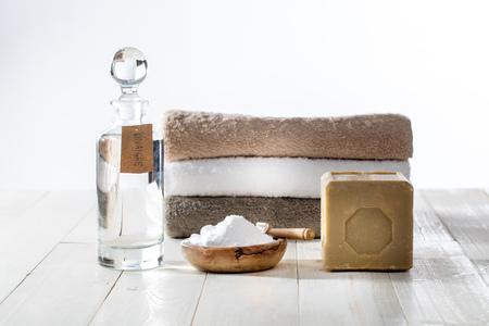 Sustainable cleaning laundry with chic homemade detergents and softener with traditional Marseilles soap, vinegar and baking soda for fluffy folded towels on wooden backgroundの写真素材