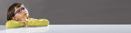 panoramic banner of inspired childhood with small beautiful girl with eyeglasses looking away...