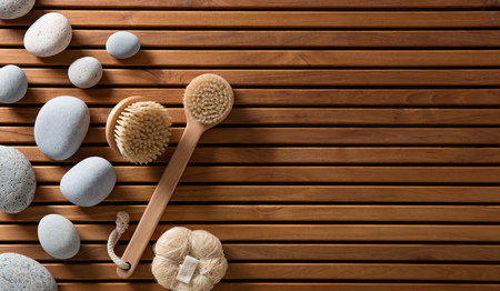 zen pebbles set on Turkish bath wooden board with exfoliating body brushes for eco-friendly spa, massage or sauna, copy space still life, top viewの写真素材