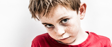portrait of a unhappy little kid expressing bullied disillusion, fragile loneliness, fear and sadness, contrast effectsの写真素材