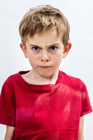stunned outraged boy with freckles and angry eyes frowning for danger, fear or domestic violence...