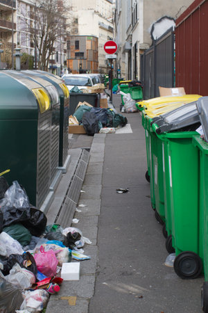 Paris dirty sidewalks loaded with recycling containers, garbage bins and many heaps of junk, plastic bags polluting the French capital cityの写真素材