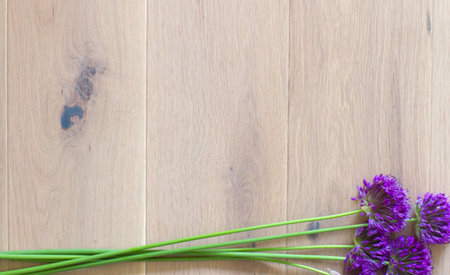 banner for celebrating gift of nature with a fresh garden bouquet of big chives flowers and stems, copy space over light wooden backgroundの写真素材