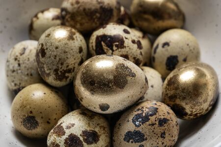 Easter quail eggs in a plate on an old wooden background, place for textの写真素材