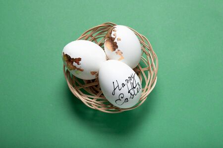 Beautiful Easter eggs in a basket on a green background, Place for text, Top view,の写真素材