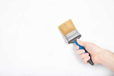 The guy holds a brush in his hand. White wall, repair. builderの写真素材