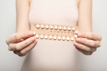 Girl holds birth control pills in her hands. Contraceptionの写真素材
