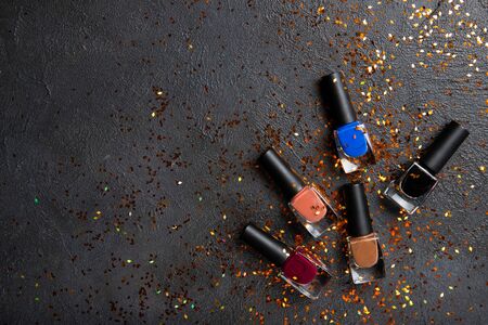 Nail polish on a black background. Colored nail polishes. Place for textの写真素材