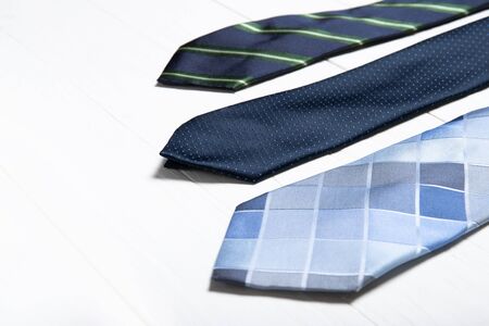 Men's ties on a white wooden background. Place for textの写真素材