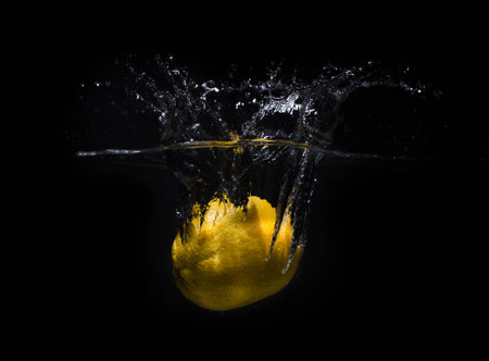 Fresh lemon dropped into waterの写真素材